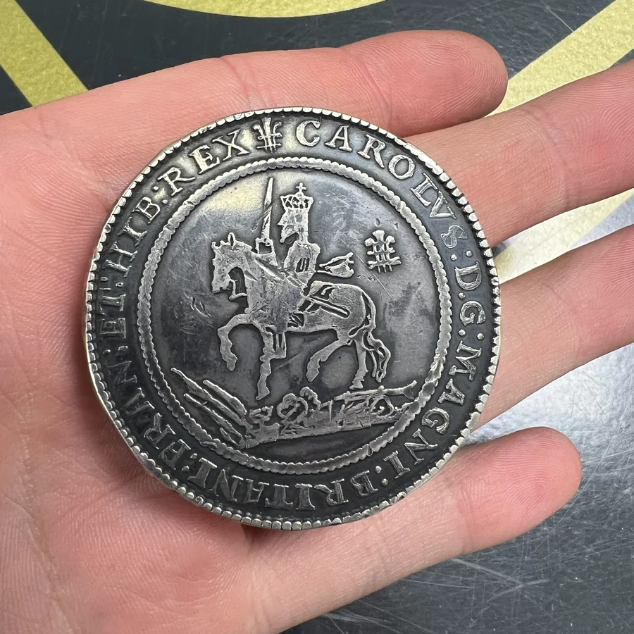 An unidentified historic silver coin held carefully for inspection