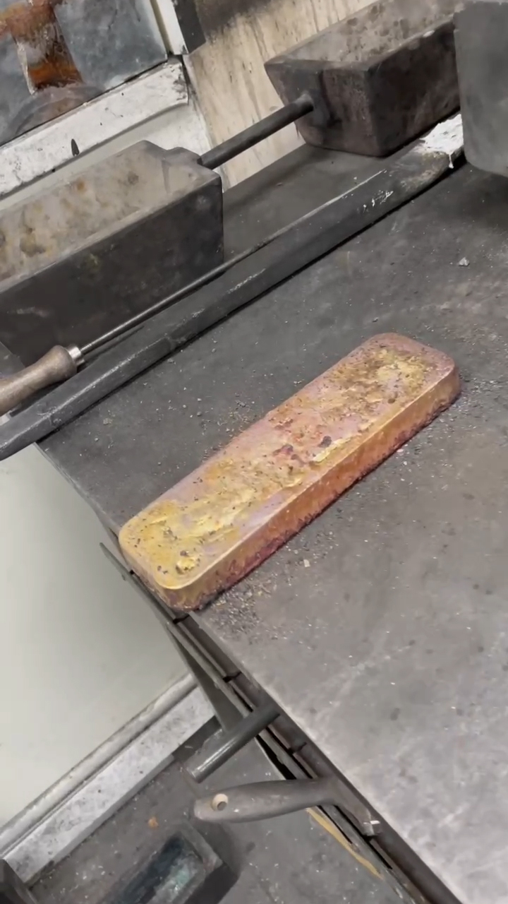 Cooled pure gold bar resting on the table