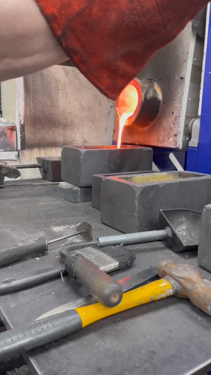 Molten gold flowing from the crucible into a 10kg bar mould